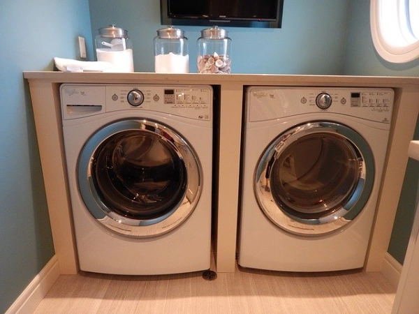 front load washer and dryer in a blue colored laundry room