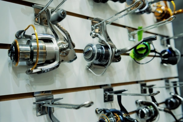 photo of a variety of spinning fishing reels hanging on a display wall