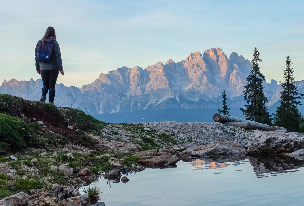 rearview of a woman hiker looking at a mountain range