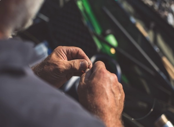 up close overhead angle view of a man threading a fishing hook